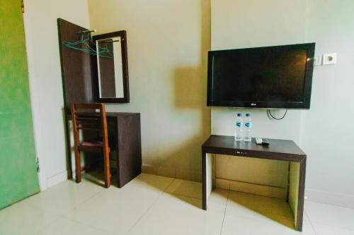 a living room with a flat screen tv and a table at Bidari Hotel Lombok in Tjakranegara