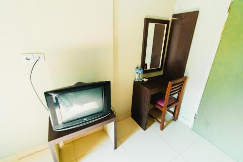 a tv sitting on a table next to a mirror at Bidari Hotel Lombok in Tjakranegara