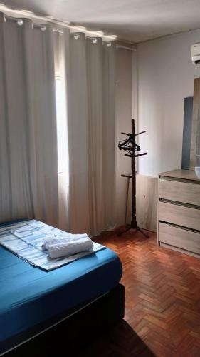 a bedroom with a bed and a cross on the wall at Morada do Altíssimo I in Uruguaiana