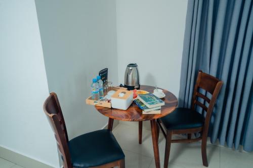 a wooden table with two chairs and a coffee maker on it at White Corner Hotel in Phnom Penh