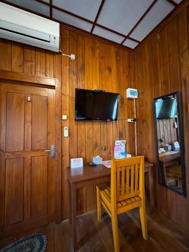 a room with a wooden wall with a table and a chair at Villa Robert in Pineleng