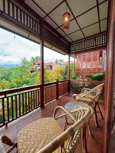 a screened in porch with two chairs and a table at Villa Robert in Pineleng