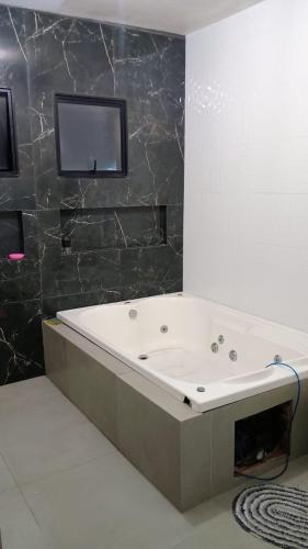 a bath tub in a bathroom with a mirror at Morada do Altíssimo I in Uruguaiana