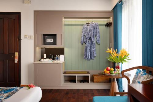 una camera da letto con un vestito appeso a una finestra di Vinh Hung Riverside Resort & Spa a Hoi An