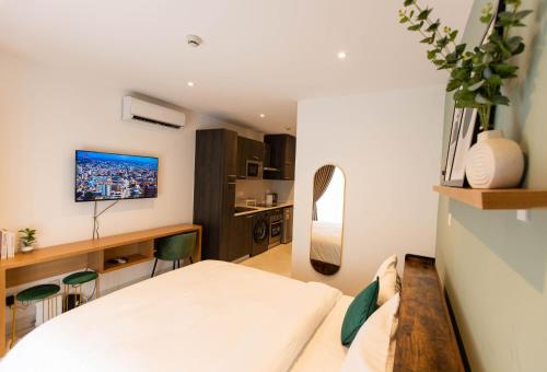 a small bedroom with a bed and a kitchen at Vibrant Studio at Loxwood House in Accra