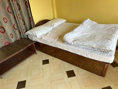 Un dormitorio pequeño con una cama con sábanas blancas. en Gate of Himalaya hotel and apartment, en Pokhara