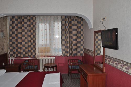 a hotel room with a bed and a tv and chairs at Saray Hotel in Edirne