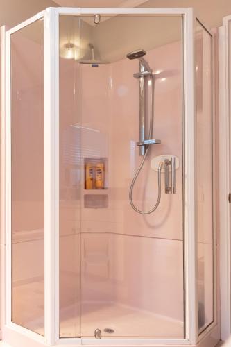 a shower with a glass enclosure in a bathroom at Observation Holiday Home in Paraparaumu Beach