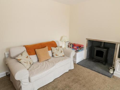 a white couch in a living room with a fireplace at 7 Cummertrees in Annan