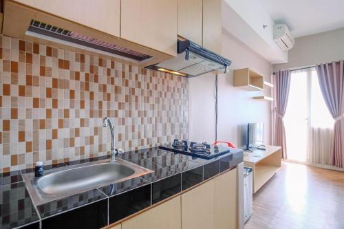 une cuisine avec un évier et un plan de travail dans l'établissement Cozy Stay and Warm Studio Apartment at Margonda Residence 5 By Travelio, à Depok