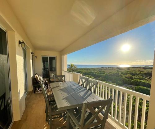 a dining table on a balcony with a view of the ocean at Seas the Day TCI -Sonos, Covered Balcony, hot tub in Wheeland Settlement