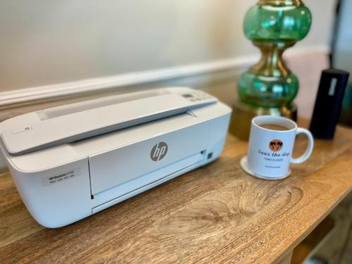 a white printer and a cup of coffee on a table at Seas the Day TCI -Sonos, Covered Balcony, hot tub in Wheeland Settlement