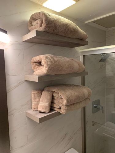 a bathroom with shelves with towels and a shower at Seas the Day TCI -Sonos, Covered Balcony, hot tub in Wheeland Settlement