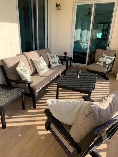 a living room with couches and a coffee table at Seas the Day TCI -Sonos, Covered Balcony, hot tub in Wheeland Settlement