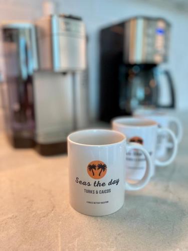 two coffee mugs sitting on top of a counter at Seas the Day TCI -Sonos, Covered Balcony, hot tub in Wheeland Settlement