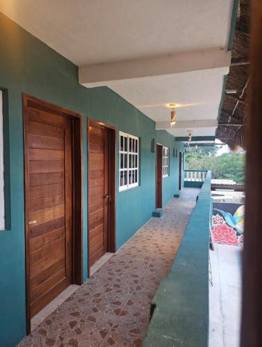 a hallway of a house with green walls and wooden doors at Luz de Luna Mahahual in Mahahual