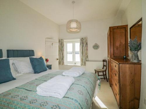 a bedroom with a bed with white pillows on it at Clamoak Cottage in Yelverton