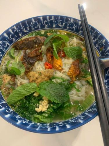 un tazón de sopa con carne y verduras y palillos chinos en Infinity Hotel, en Thái Bình