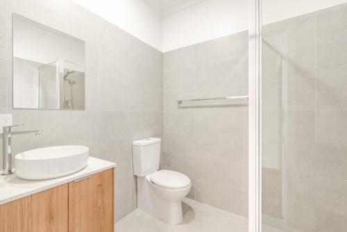 a bathroom with a toilet and a sink and a shower at Canterbury Street Apartments in Casino