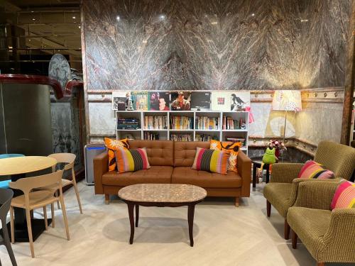 a living room with a couch and a table and chairs at Happiness Hotel in Taipei