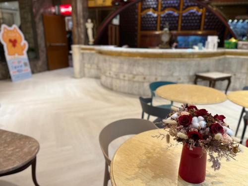 a table with a bouquet of flowers on top of it at Happiness Hotel in Taipei