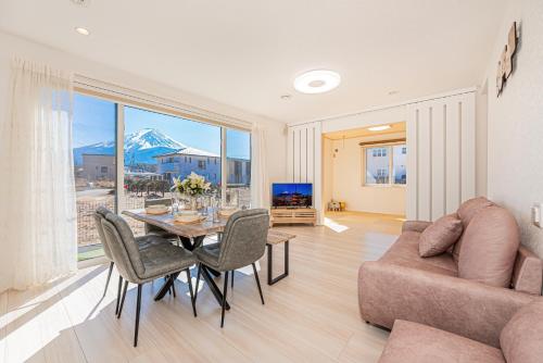 a living room with a table and a couch at New Open! Collab House 富士山眺望 送迎無料 BBQ 器具無料貸出 in Fujikawaguchiko