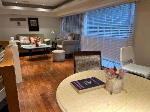 a living room with a table and a couch at Happiness Hotel in Taipei