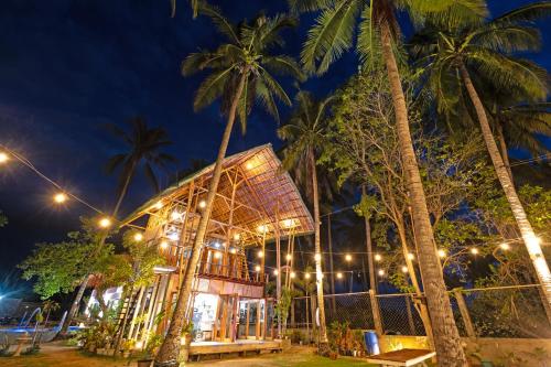 a building with palm trees at night at Angeles Hut Fishermans Wharf in Laguindingan