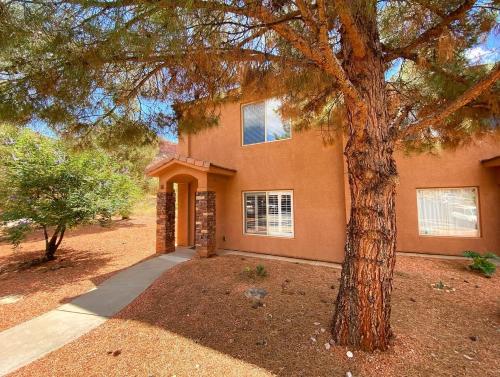 ein Haus mit einem Baum davor in der Unterkunft Kanab Townhome Pool and Hot Tub Pets OK in Kanab