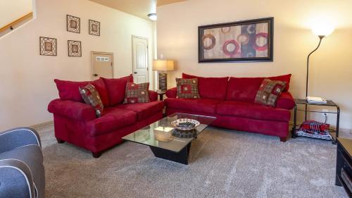 ein Wohnzimmer mit einem roten Sofa und einem Tisch in der Unterkunft Kanab Townhome Pool and Hot Tub Pets OK in Kanab