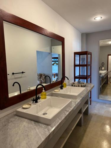 a bathroom with two sinks and a large mirror at Uluwatu Stay's Deluxe Suite #5 in Uluwatu