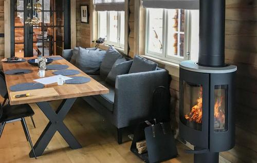 a fireplace in a living room with a table and a stove at Pet Friendly Home In Hovden I Setesdal in Hovden