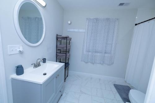 une salle de bain blanche avec un lavabo et un miroir dans l'établissement Modern Luxury Home With Fireplace & Game-Room, à Brockton
