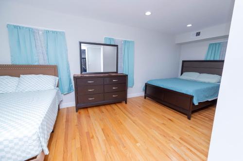 - une chambre avec deux lits et une commode avec un miroir dans l'établissement Modern Luxury Home With Fireplace & Game-Room, à Brockton