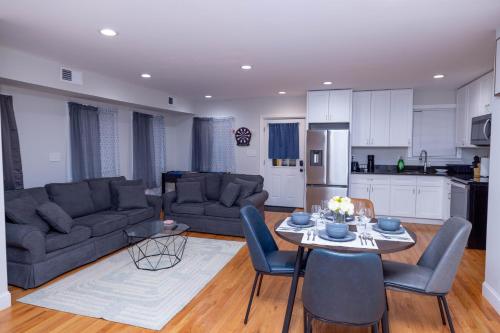 a living room with a couch and a table with chairs at Modern Luxury Home With Fireplace & Game-Room in Brockton