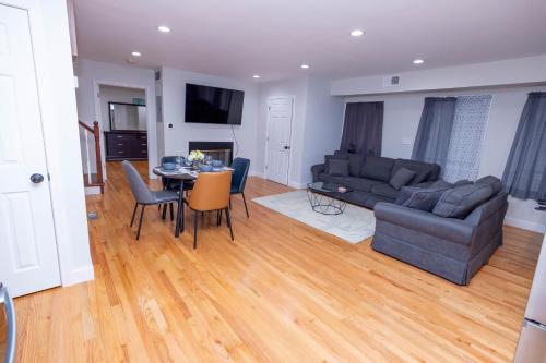 a living room with a couch and a table at Modern Luxury Home With Fireplace & Game-Room in Brockton