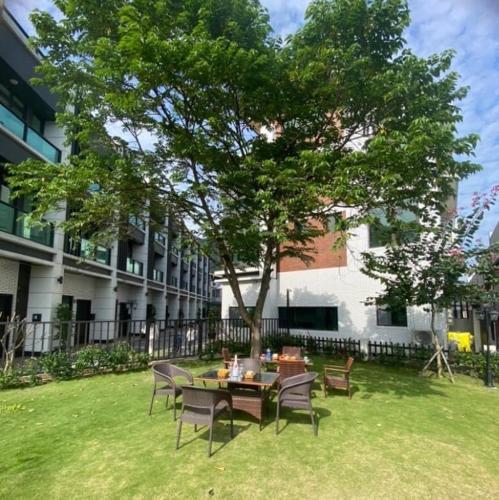 a table and chairs under a tree in a yard at Ocean Blue Homestay in Fan-shu-liao