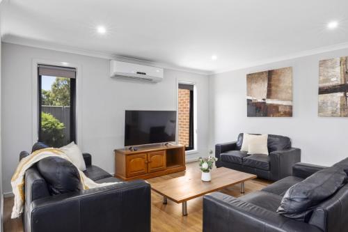 Una sala de estar con dos sofás y un televisor. en Bendigo Signature Accommodation on Averys, en Eaglehawk