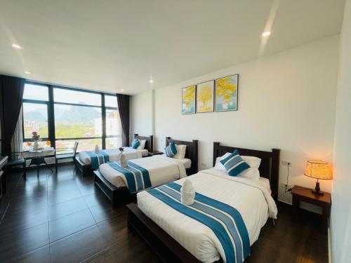 a hotel room with two beds and a desk at VANG VIENG TOPVIEW HOTEL in Vang Vieng