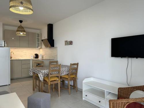une cuisine et une salle à manger avec une table et des chaises dans l'établissement Appartement Moderne avec Jardin et Grande Terrasse, proche Plage et Commerces - Le Lavandou - FR-1-251-835, au Lavandou