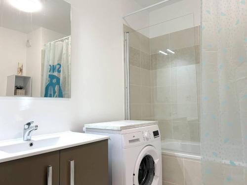 une salle de bain avec une machine à laver et un lavabo dans l'établissement Appartement Moderne avec Jardin et Grande Terrasse, proche Plage et Commerces - Le Lavandou - FR-1-251-835, au Lavandou
