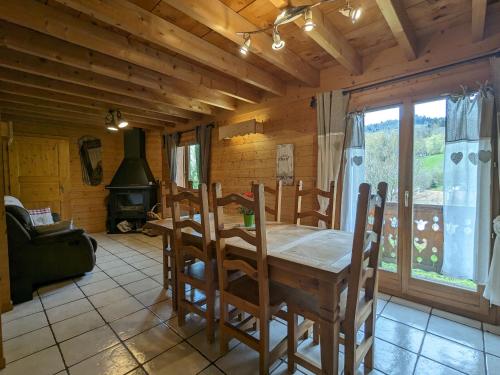 une salle à manger avec une table et des chaises et une cheminée dans l'établissement Chalet spacieux à La Bresse, idéal pour familles et amis - FR-1-589-679, à La Bresse