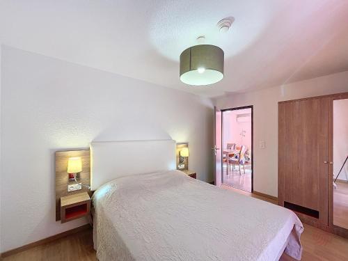 une chambre avec un lit et une table avec une lampe dans l'établissement Bel F3 climatisé avec parkings, terrasse et vue sur montagnes à 50m du centre et des thermes - FR-1-451-213, à Lamalou-les-Bains