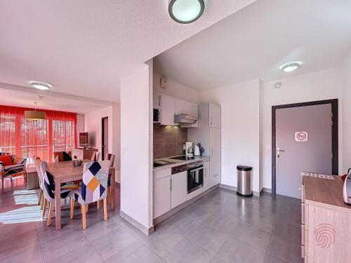 une cuisine et une salle à manger avec une table et une salle à manger dans l'établissement Bel F3 climatisé avec parkings, terrasse et vue sur montagnes à 50m du centre et des thermes - FR-1-451-213, à Lamalou-les-Bains