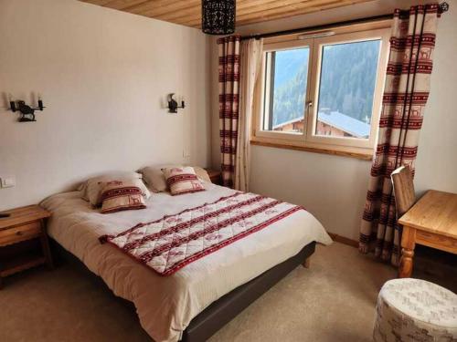 une chambre avec un grand lit avec une fenêtre dans l'établissement Chalet 3 pièces avec WIFI, parking et terrasse à Châtel - FR-1-676-205, à Châtel