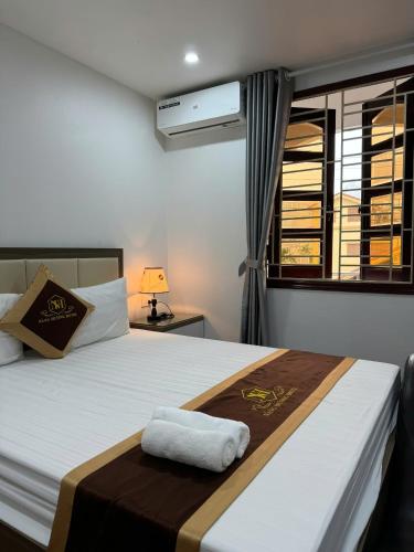 a bedroom with a bed with a towel on it at NH Hotel in Hanoi