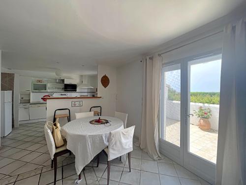 une cuisine et une salle à manger avec une table et une fenêtre dans l'établissement Maison spacieuse climatisée, proche centre - FR-1-475-218, à Saintes-Maries-de-la-Mer