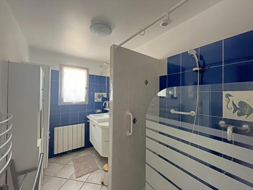 une salle de bain bleue avec une douche et un lavabo dans l'établissement Maison spacieuse climatisée, proche centre - FR-1-475-218, à Saintes-Maries-de-la-Mer