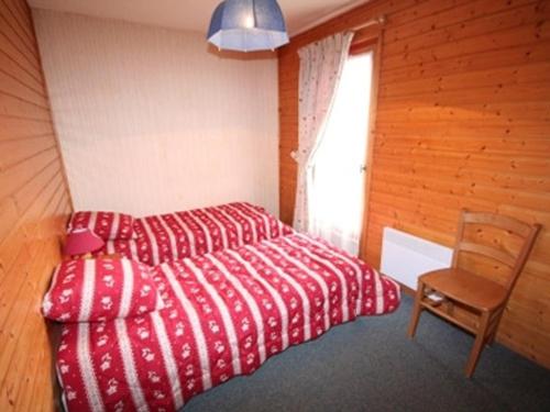 - une chambre avec un lit rouge et une chaise dans l'établissement Appartement 4 pièces, 3 chambres, 8 pers, Châtel, Animaux permis, Parking - FR-1-676-219, à Châtel