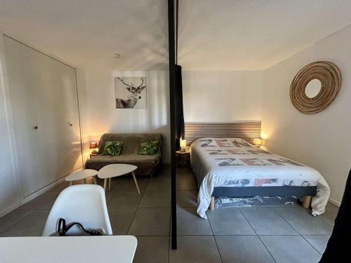 une petite chambre avec un lit et un canapé dans l'établissement Studio confortable 4 pers à 2 pas du port avec terrasse - FR-1-225D-221, à Saint-Cyprien